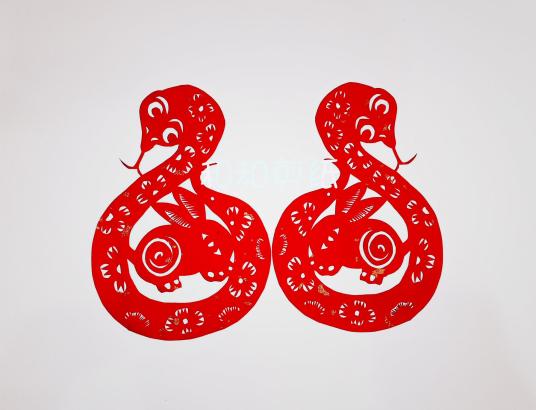 Two stylized detailed red papercuttings each depict a snake curled around a rabbit.