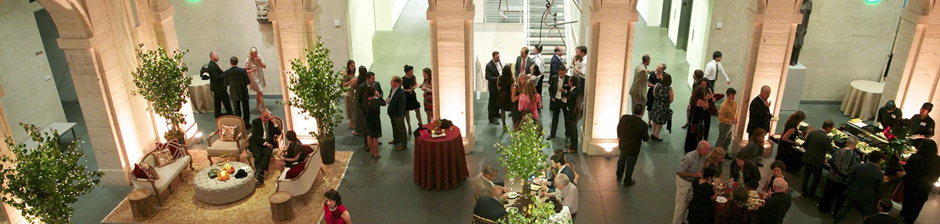 A crowd gathers at a formal reception in the Calderwood Courtyard.