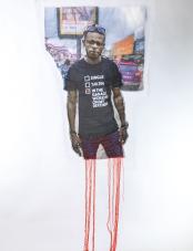 A print on white fabric features a Black man in a black shirt with white text. Red and orange threads hang from the bottom of the work.  Un imprimé sur tissu blanc représente un homme noir portant une chemise noire avec du texte blanc. Des fils rouges et oranges pendent du bas de l'œuvre.