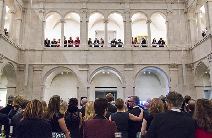 A group of visitors gather for a corporate event in the courtyard.