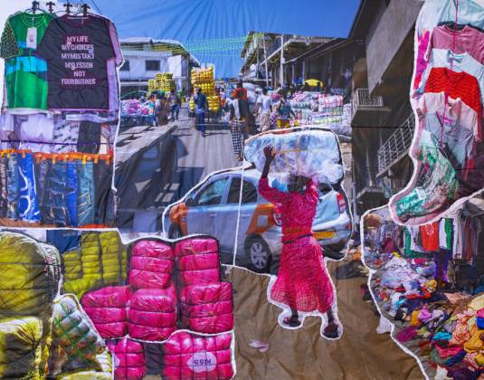 A colorful, mosaic-like street scene depicting a busy market with people carrying goods on their heads and on carts.
