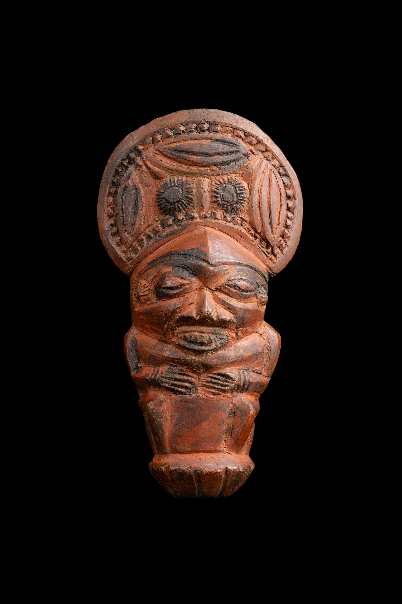 A small terracotta figurine with an oval headpiece.